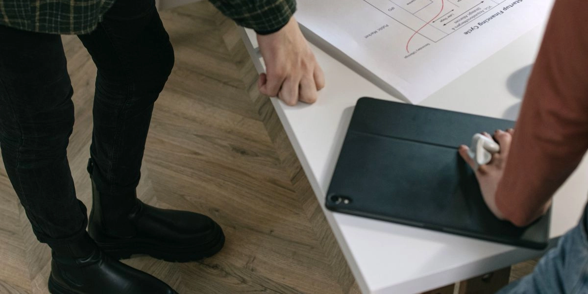 A team reviewing a hand-drawn process flow diagram on paper