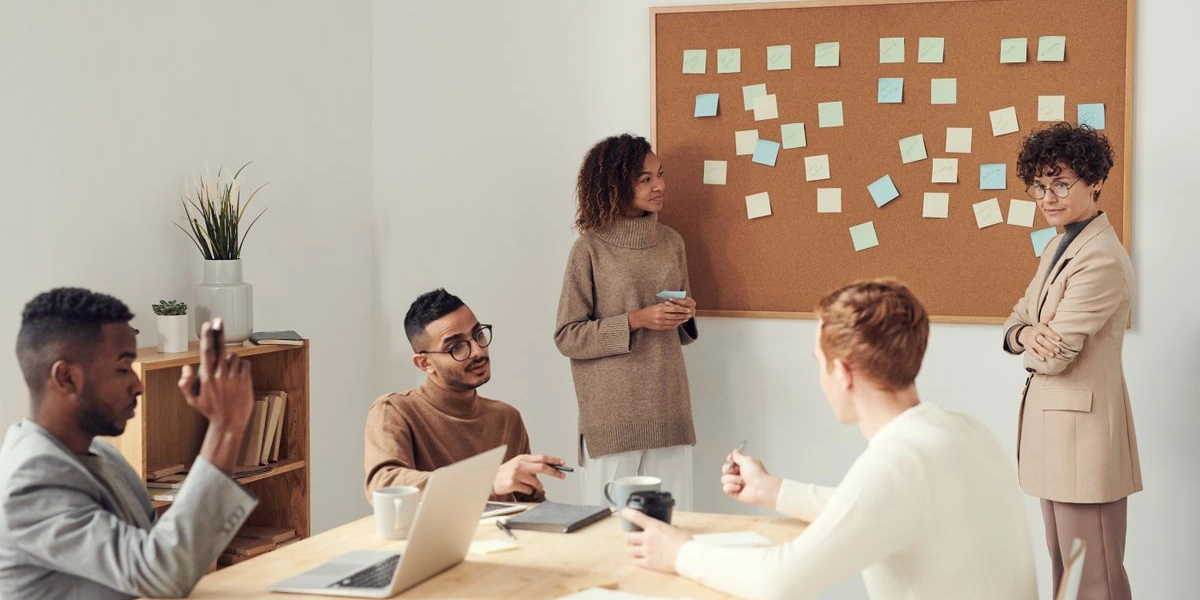 A team gathered around a sticky-note task board during a planning meeting